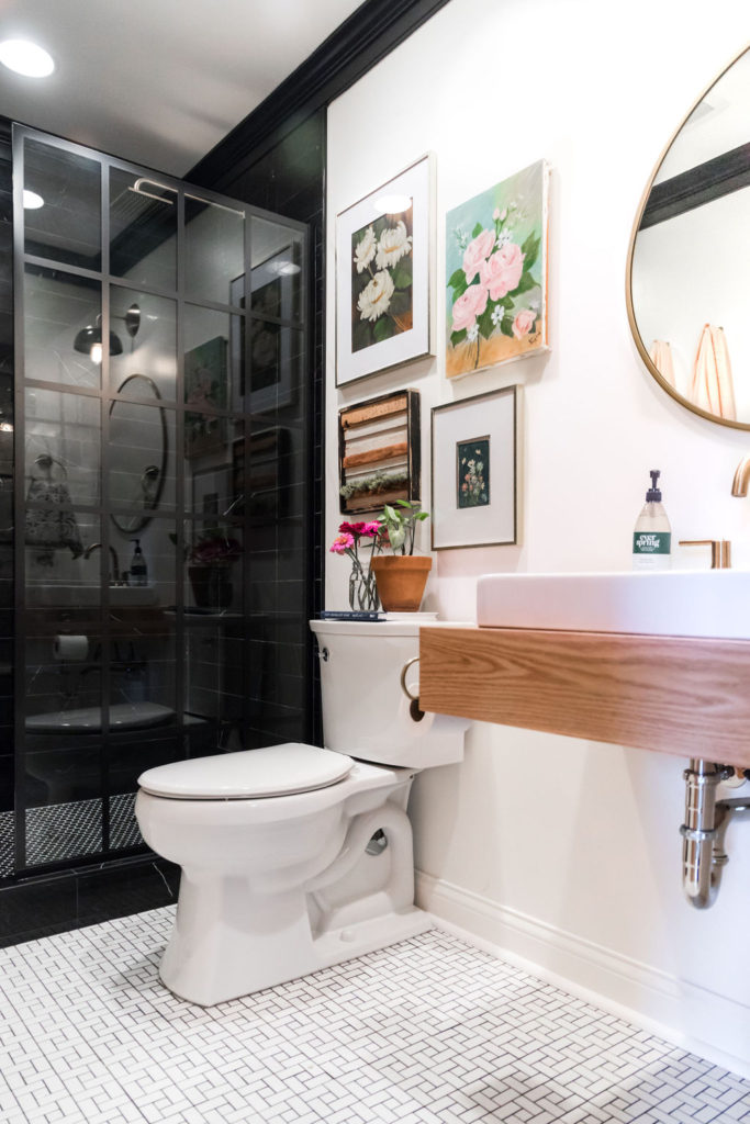 Bidet toilet in white bathroom with pictures around it and sink.