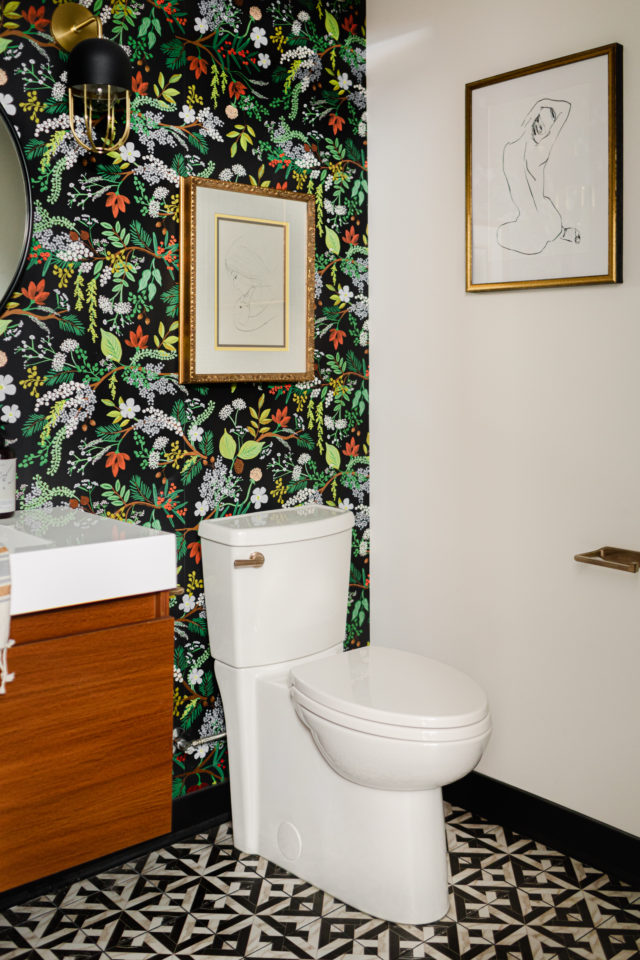 a bathroom with a bold wallpaper wall and two pices of art in antique gold frames is a true representation of the future of interior design 