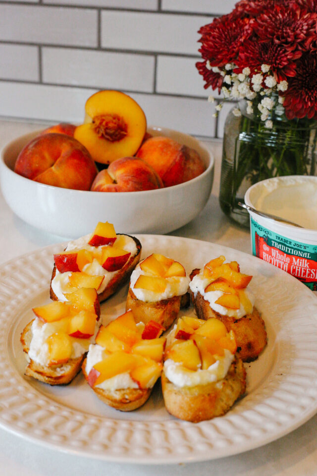 Grilled french baguette topped with ricotta and cubed peaches for crostini