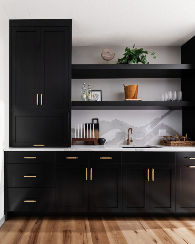 a wet bar with black cabinets, floating shelves, a quartz countertop going into a backsplash and hardwood floors