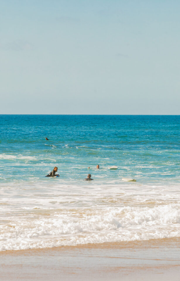 photo of the Pacific Ocean with men surfing who chose to go on a beach getaway 