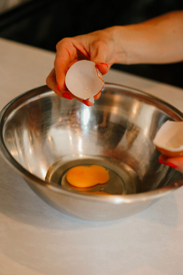 cracking eggs into a bowl to start making batter for Biscotti | Biscotti vs Cantucci: What is the Difference? 