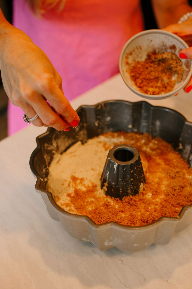 cinnamon brown sugar mixture is being placed on top of the cake batter