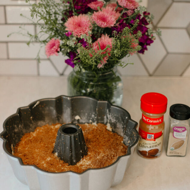 coffee cake batter in the bundt pan topped with cinnamon brown sugar mixture and is ready to be placed in the oven