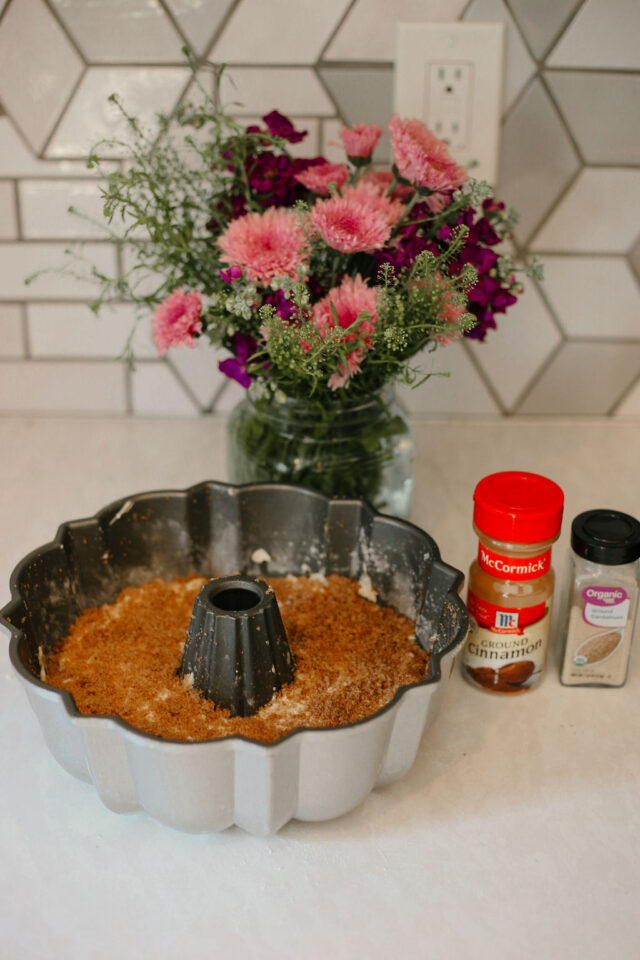 coffee cake batter in the bundt pan topped with cinnamon brown sugar mixture and is ready to be placed in the oven