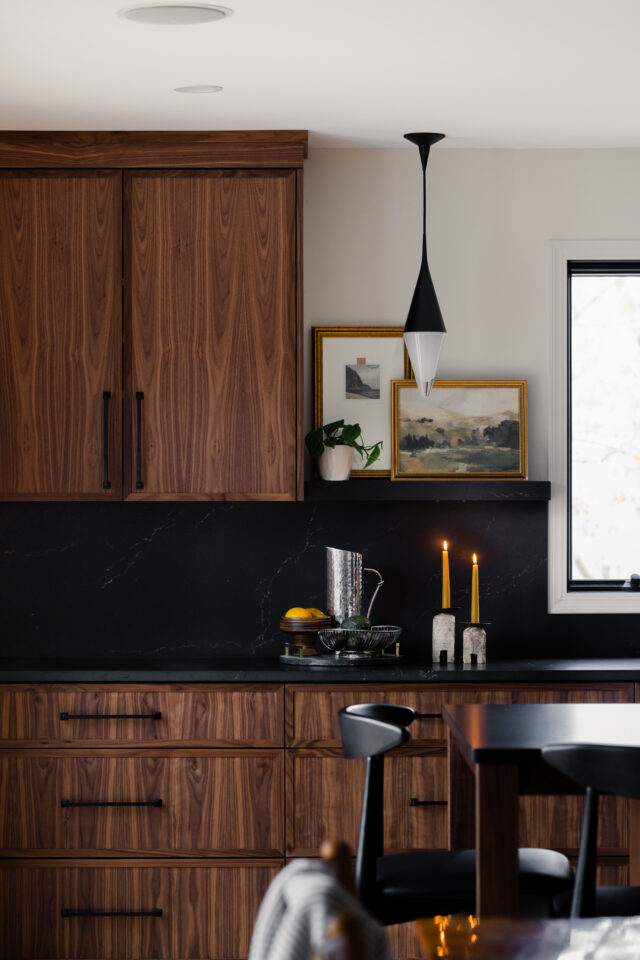 saturated and moody colors in the kitchen with a black countertop and a modern light fixture is a real future of interior design | 2025 interior design trends