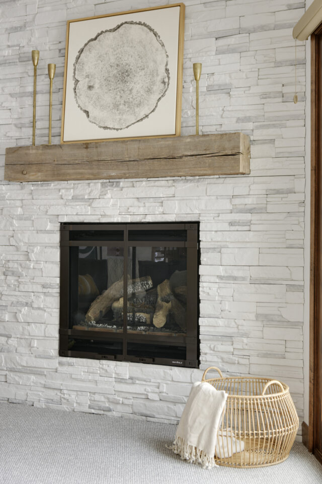 a photo of a custom stone fireplace with a reclaimed wood mental | one of 2025 interior design trends