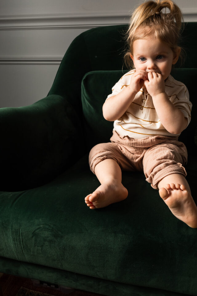 a toddler playing on a jewel tones couch | interior design trends 2025 