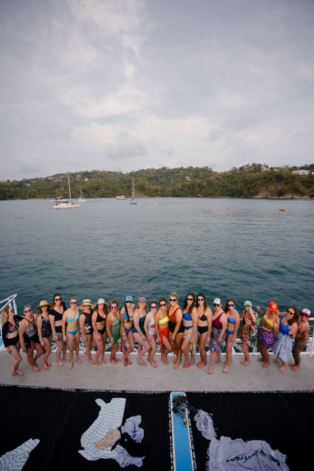 a group photo of all the attendees of contractor conference for women, held annually in costa rica, standing on the yacht 