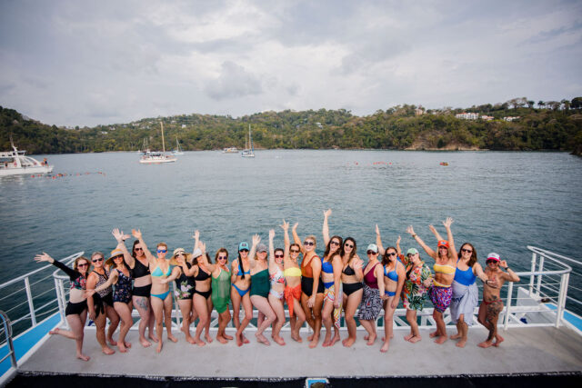 a group photo of all the attendees of contractor conference for women, held annually in costa rica, waving at the photograher on the yacht | buildher retreat 2025