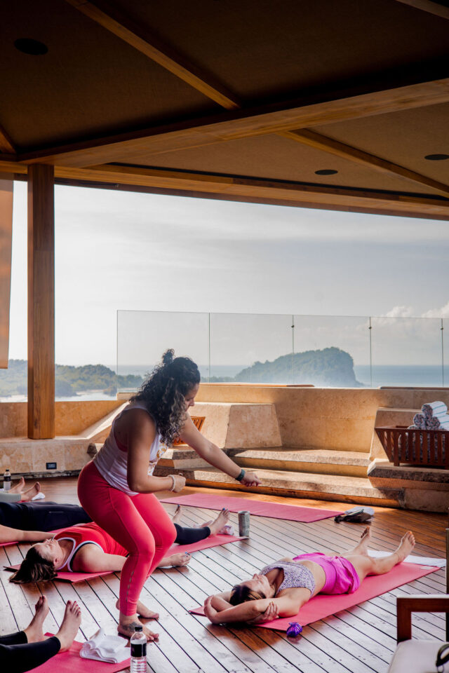 a photo of a woman leading a yoga session at a contractor conference for women in costa rica 