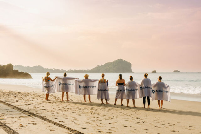 eight female contractors with buildertrend towels in costa rica on the beach 