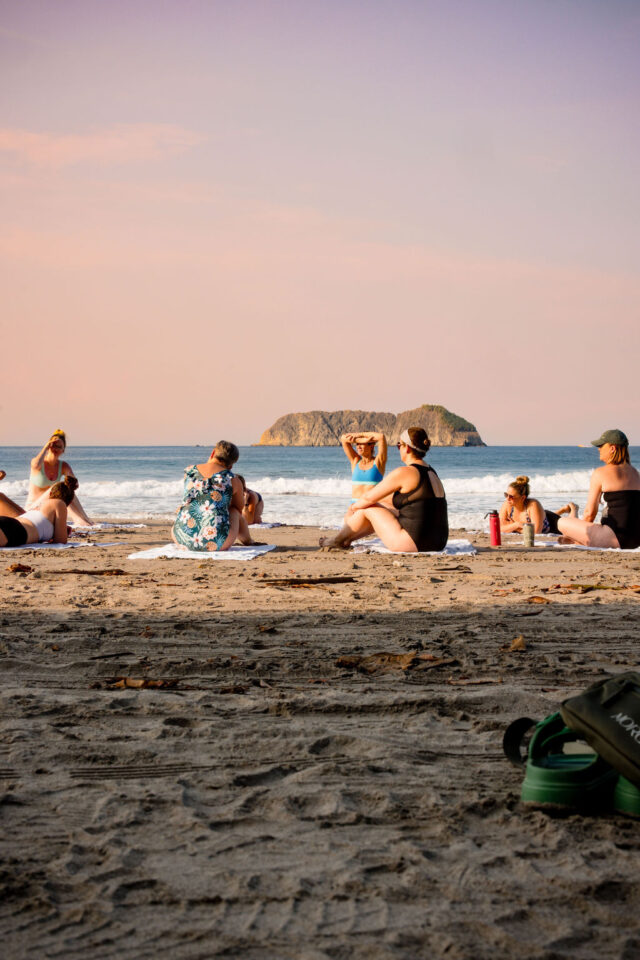 female contractors just finished their yoga session on the beach in costa rica | buildher retreat 2025