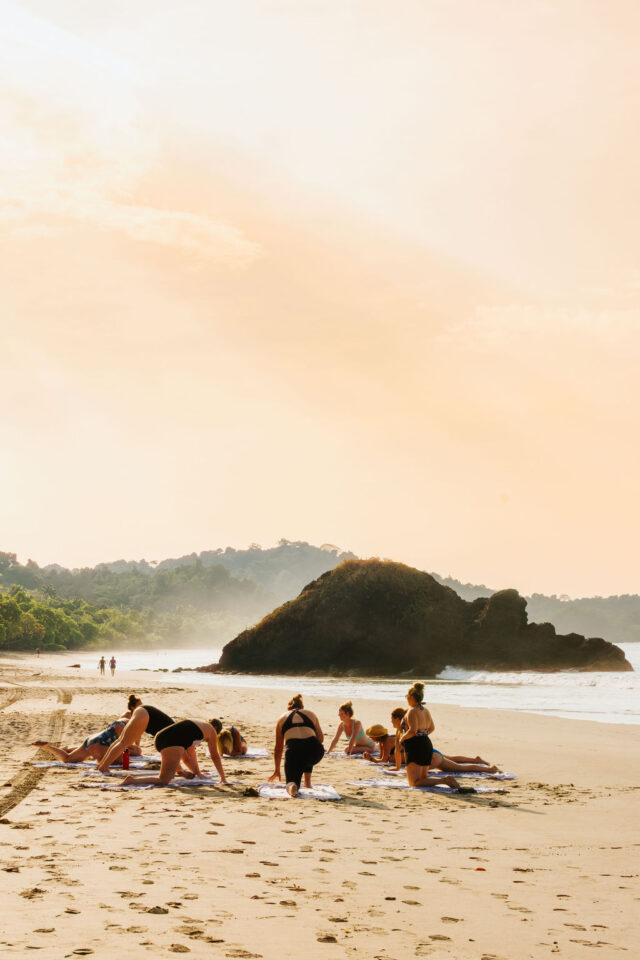 a photo of women contractors doing yoga on the beach in costa rica while on buildher retreat in 2025