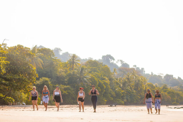 a photo of 7 female contractors walking on the beach in costa rica during contractor conference for women 