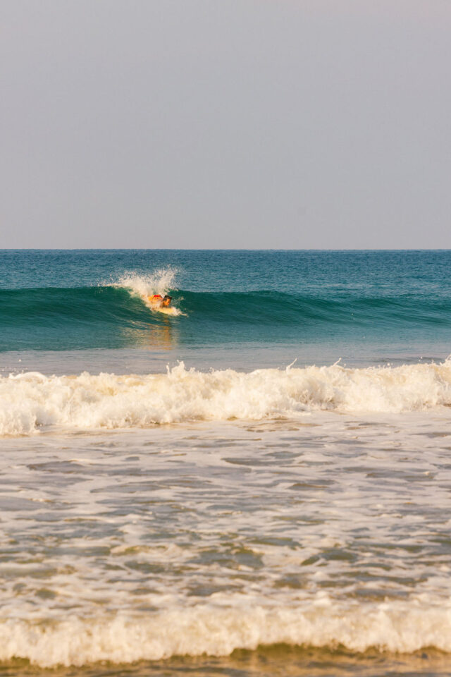 a photo of a woman on her board surfing in costa rica during buildher retreat 2025