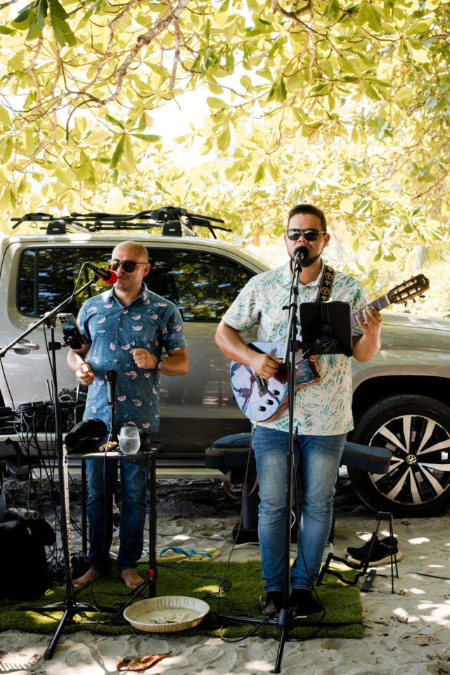 two men singing in front of microphones in costa rica