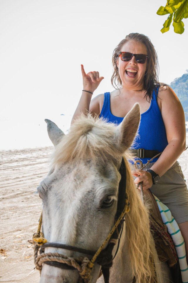 a close-up photo of a female builder riding a horse on the beach in Costa Rica, while attending contractor conference for women called buildher retreat 2025