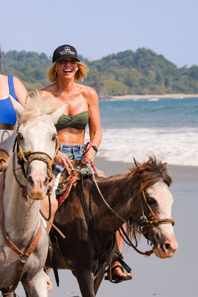 a photo of two female builders riding horses on the beach in Costa Rica, while attending contractor conference for women called buildher retreat 2025