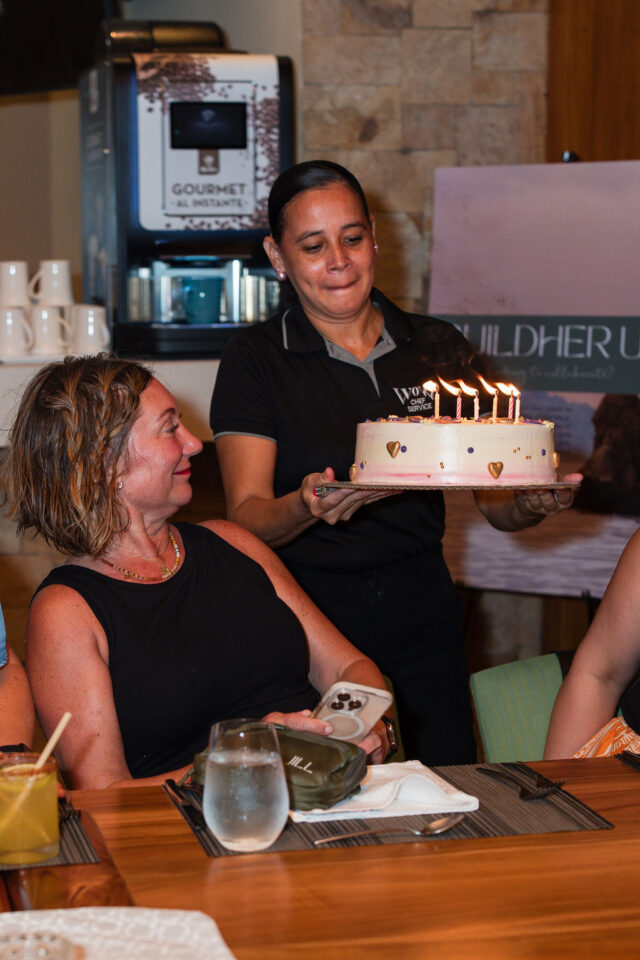 a photo of Jill Jensen from construction2style crew looking at her birthday cake while attending a conference for women builders in costa rica 