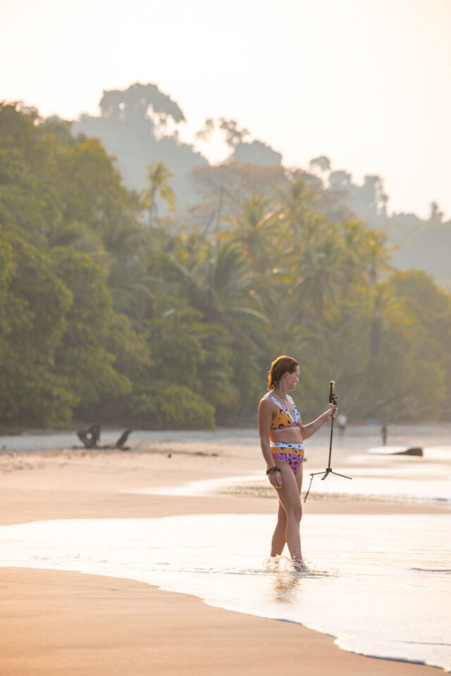 Morgan Molitor of construction2style holding a phone with a phone tripod stand in the ocean at contractor conference for women called buildher retreat 2025 held in Costa Rica