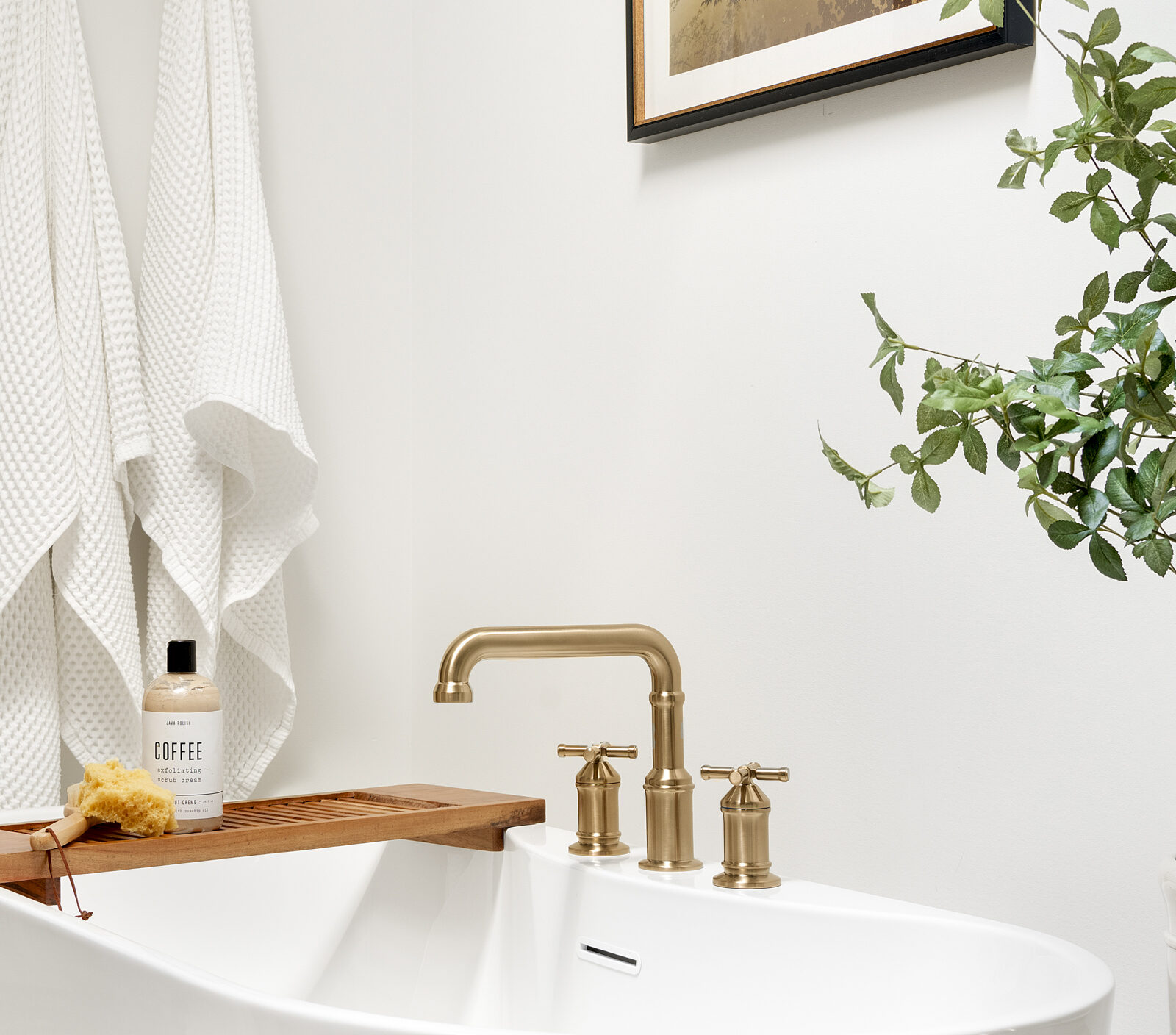 a photo of a primary bathroom designed and built by construction2style, it features a great freestanding tub with gold hardware