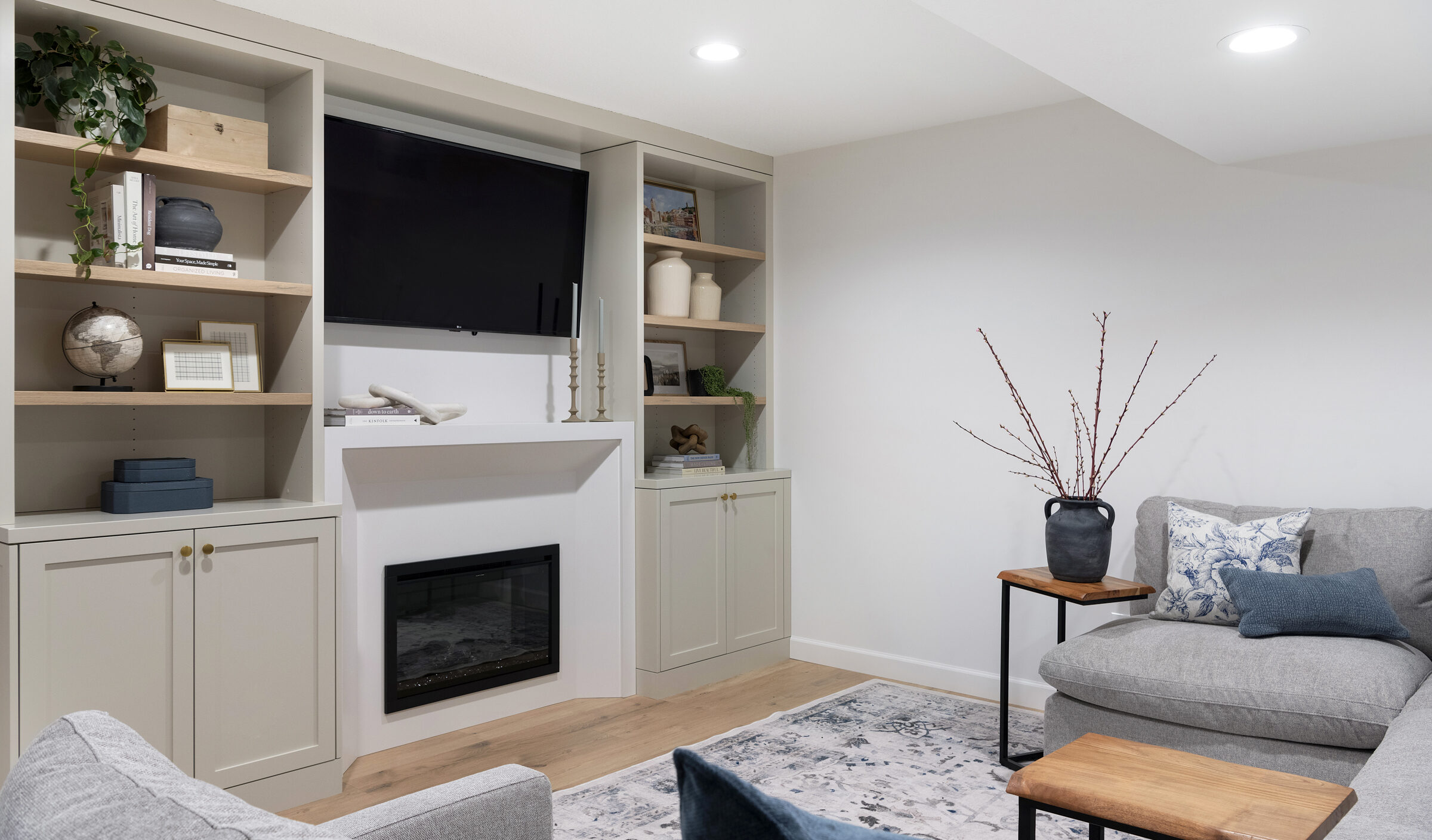 a photo of an Entertainment wall on the left and a comfy sectional with a side table on the right | construction2style