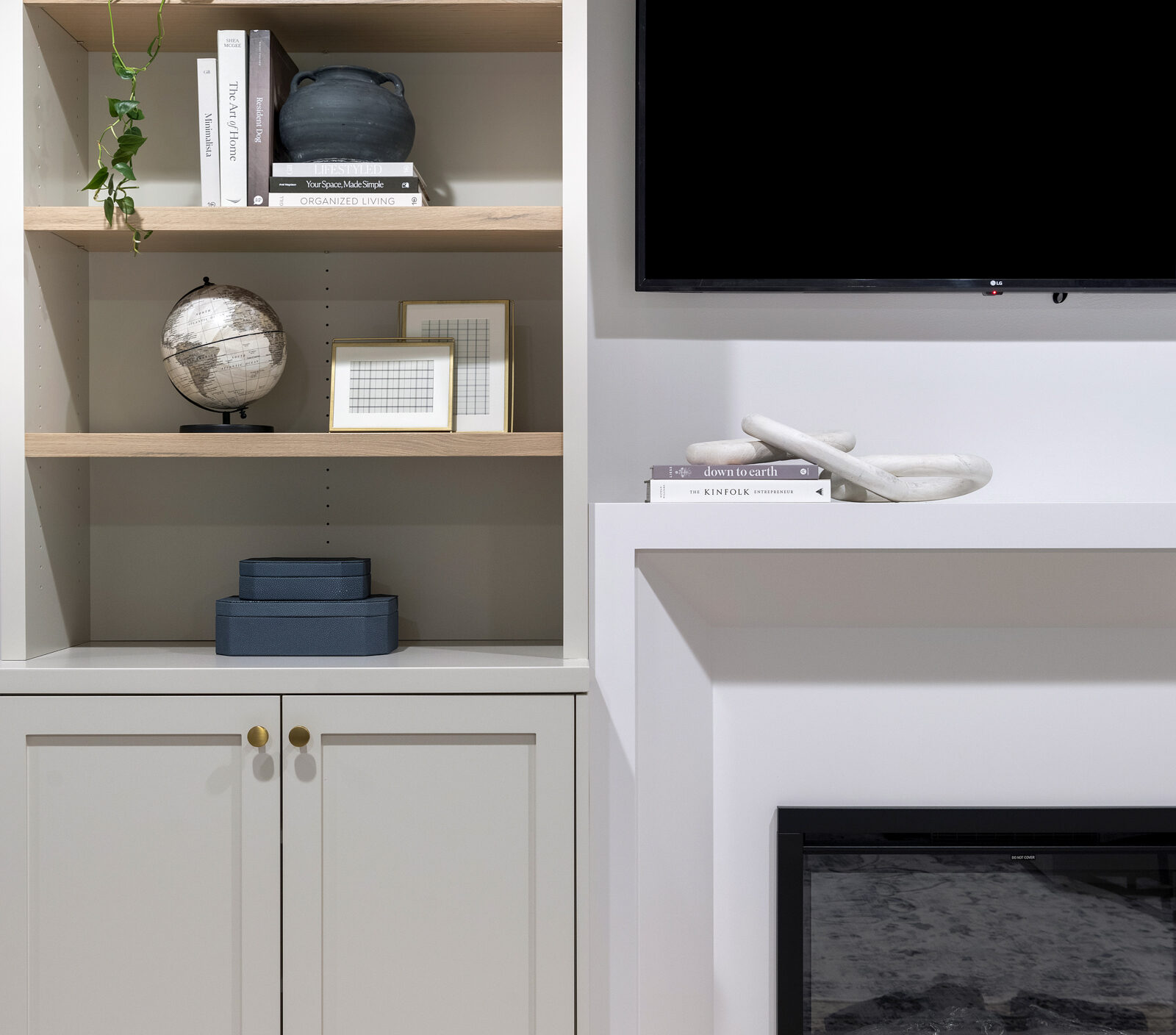 a photo of an Entertainment wall designed by construction2style that Includes base cabinetry with a custom fireplace surround, frameless upper cabinetry down to the countertop with rift sawn white oak